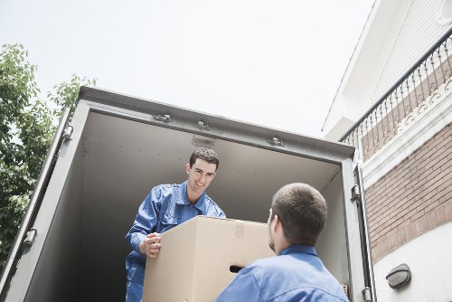 Local movers transporting household furniture through a Colneyhatch street